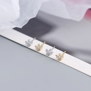 Detailed view of silver and gold crown leaf earrings with shimmering zircon crystals