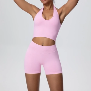 Detail of pink seamless knit yoga set showing ribbed texture on halter top and high-waist shorts
