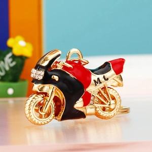 Close-up of red and black motorcycle keychain with rhinestones and golden metal frame