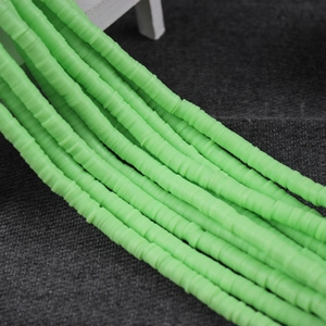 Macro detail of vibrant green 4/6mm polymer clay disc beads for DIY jewelry making
