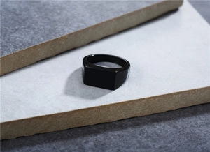 Detail view of a minimalist black square signet ring made of polished titanium steel