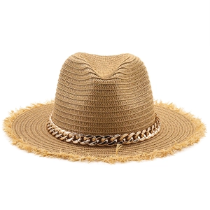 Close-up of raffia sun hat with golden metal chain and frayed straw brim detail