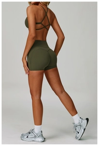 Detail of cross back sports bra and high waist fitness shorts in dark green color