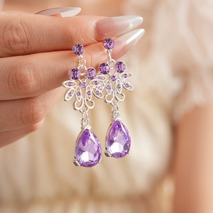 Macro shot of vintage purple zircon teardrop earrings with silver floral filigree detail