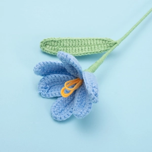 Close-up detail of handcrafted blue yarn tulip with intricate knitted texture and leaf