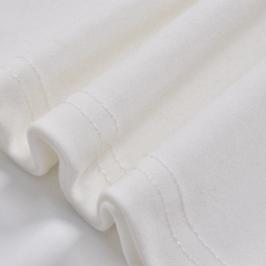Detailed macro view of white knitted fabric texture with professional double-stitched hem