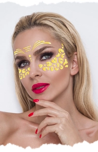 Close-up of gold glitter leopard face stickers and geometric makeup on a model