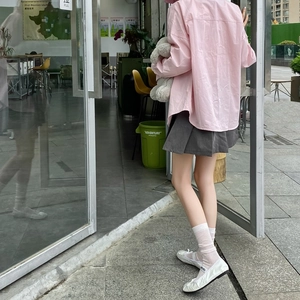 Detail of white rib-knit mid-calf socks with pink stripes paired with ballet flats