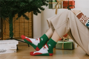 Close-up of cozy coral fleece Christmas socks featuring a festive Santa Claus pattern