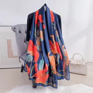 Elegant silk-like floral scarf in navy blue with vibrant red flower prints and soft draping