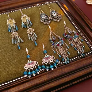 Bohemian tassel earring set with zircon floral accents in a vintage wooden frame display