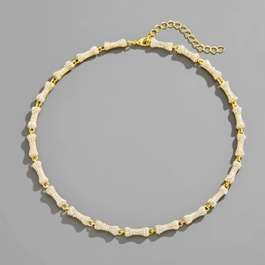 Detailed top view of gold-tone hip hop dog bone necklace with sparkling crystals