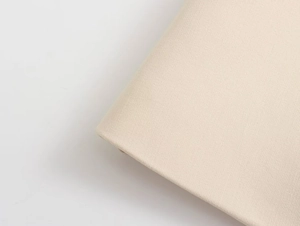 Detailed close-up of beige woven fabric showing high-quality texture and fiber pattern