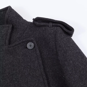 Detailed macro view of dark grey wool coat featuring epaulets and a black button
