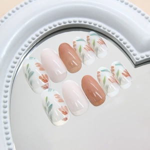 Translucent almond press-on nails with floral leaf art in creamy white and coral tones