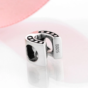 Macro view of S925 sterling silver horseshoe charm with black enamel and S925 hallmark