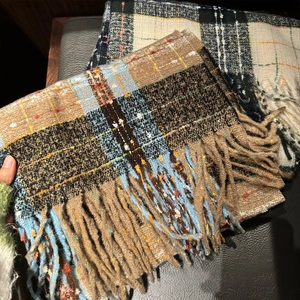 Close-up of thick checkered mohair scarf with soft fringe and detailed knit texture