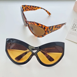 Detail showing oversized cat-eye sunglasses in leopard and black frames with color lenses