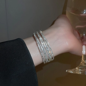 Detail of silver multi-layer rhinestone bracelet worn by model in a luxury setting