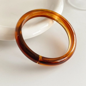 Detailed view of amber marble resin bracelet with unique translucent swirled texture