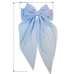 Detail of light blue chiffon bow hair clip with white dots and long streamers