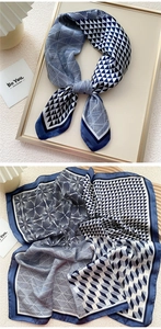 Detail of silk-like square scarf featuring navy blue geometric patterns and rolled edges