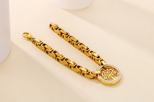 Macro detail of a gold-plated Tree of Life bracelet with pavé white cubic zirconia