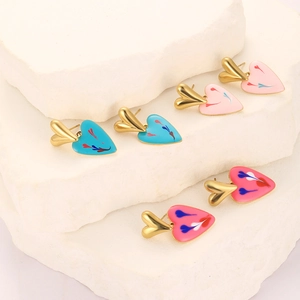 Minimalist gold heart earrings with colorful enamel dripping oil drops on stone display