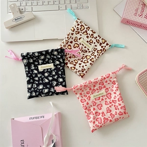 Detailed view of three mini drawstring pouches with heart leopard print in a set