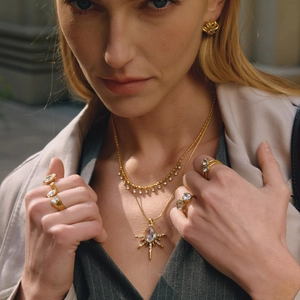 Gros plan du collier doré multicouche avec pendentif étoile et bagues en zircone
