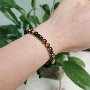 Tiger eye stone Morse code beaded bracelet You are Loved on a person's wrist