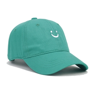Detailed embroidery of a white smiley face on a dark green cotton baseball cap for kids