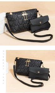 Detail of black heart-quilted crossbody bag set with golden swan ornament and tassel