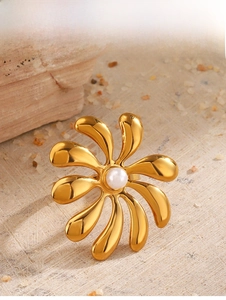 Detail shot of vintage 18K gold plated flower ring with pearl inlay on a textured background