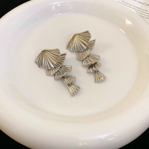 Macro shot of silver layered fan earrings showing brushed metal texture and detail