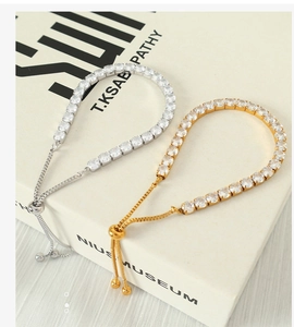 Detail of adjustable tennis bracelets with gold and silver finishes and cubic zirconia