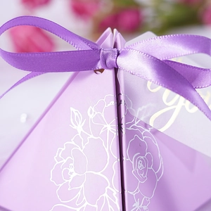 Elegant purple triangular wedding favor box with a satin ribbon and floral patterns