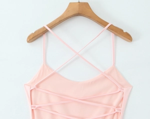 Close-up of cross-back straps on light pink dress with delicate woven texture detail