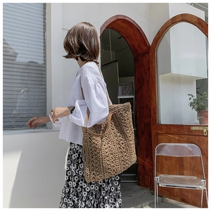 Detailed close-up of handmade woven tote bag with hollow floral patterns and leather strap