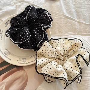 Elegant black and white polka dot tiered scrunchie set on decorative white plate