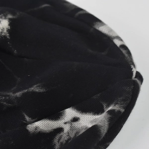 Macro shot of the black and white tie-dye knit texture and abstract skull-like print detail