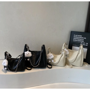 Detail of woven texture bags in black and cream with cloud charms and silver chains