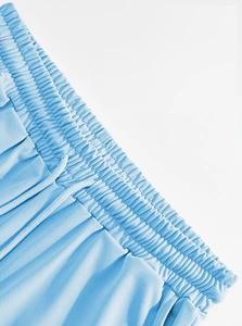 Detail of sky blue linen trousers showing elastic waistband and matching drawstring