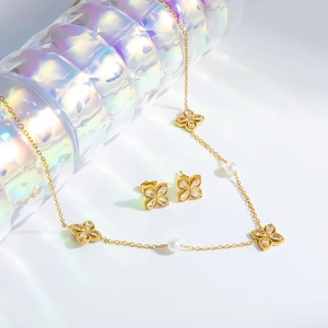 Elegant gold stainless steel four-leaf clover jewelry set with white crystals and pearls