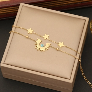Double-layered gold necklace with star and moon charms featuring turquoise beads