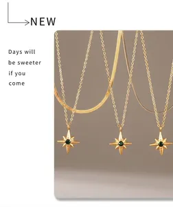 Detail of gold starburst necklace with green gemstone and layered titanium steel chains