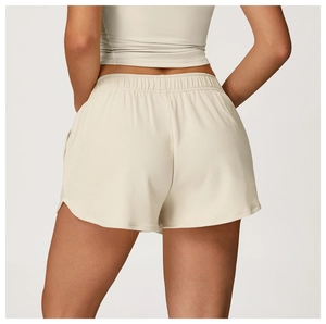 Détail de la taille élastique haute sur un short de sport crème avec fentes latérales