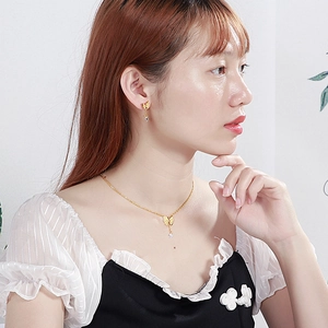 Golden butterfly necklace and earrings set with crystal rhinestones on female model