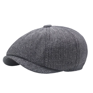 Detailed close-up of the black and white herringbone fabric on the classic newsboy cap