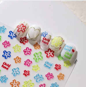 Detail of 3D embossed floral nail stickers with colorful hearts and Childhood text